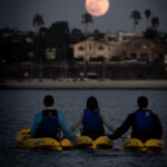 3 people on kayaks at night
